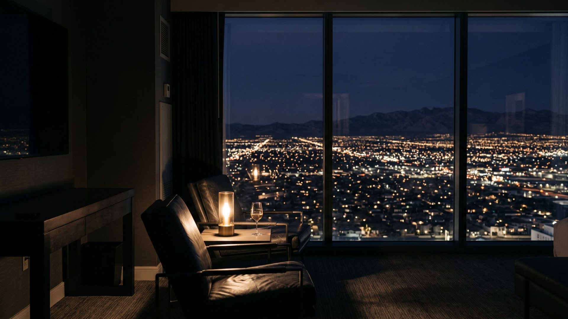 The Las Vegas valley at night seen from a dark hospitality suite high above the city